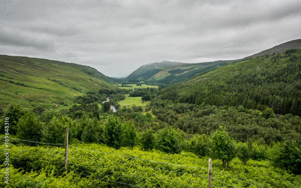 Scottish Highland valley. An overcast view over the fertile green fields and forests of the Highlands in the north west of Scotland.