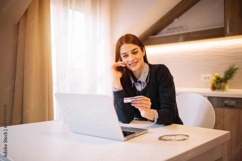 Pretty girl talking on mobile and holding credit card. Pretty girl talking on mobile and holding credit card.