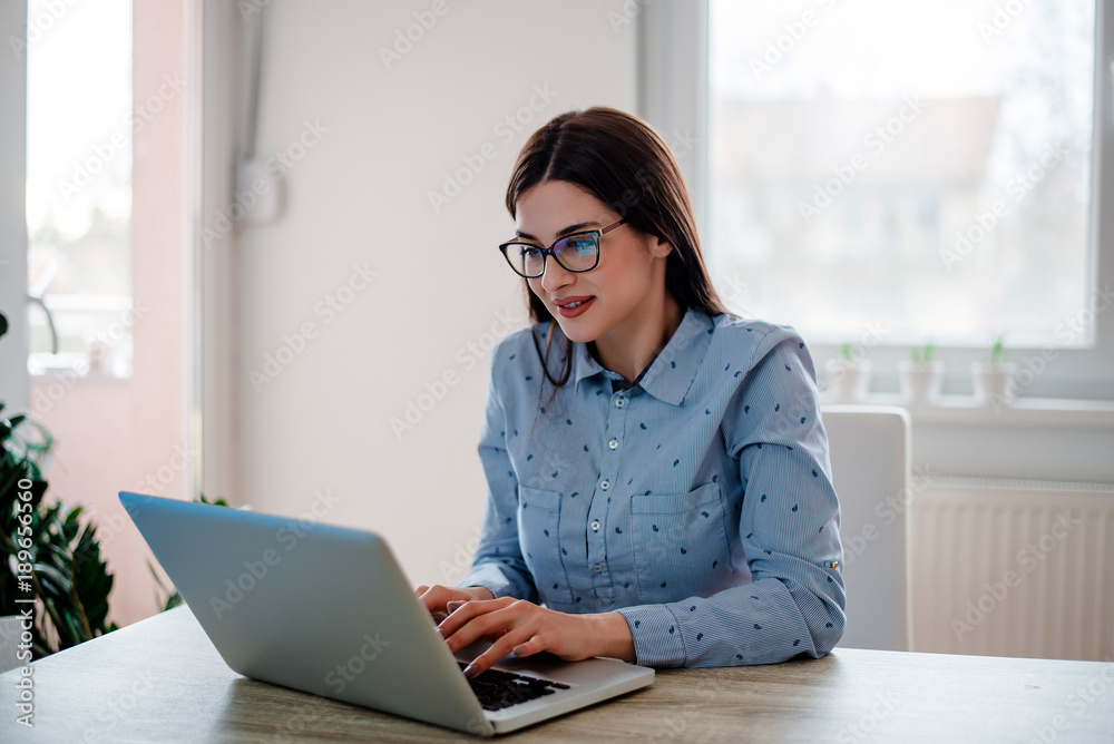 Portrait of beautiful girl with eyeglasses using laptop at home office. Portrait of beautiful girl with eyeglasses using laptop at home office.