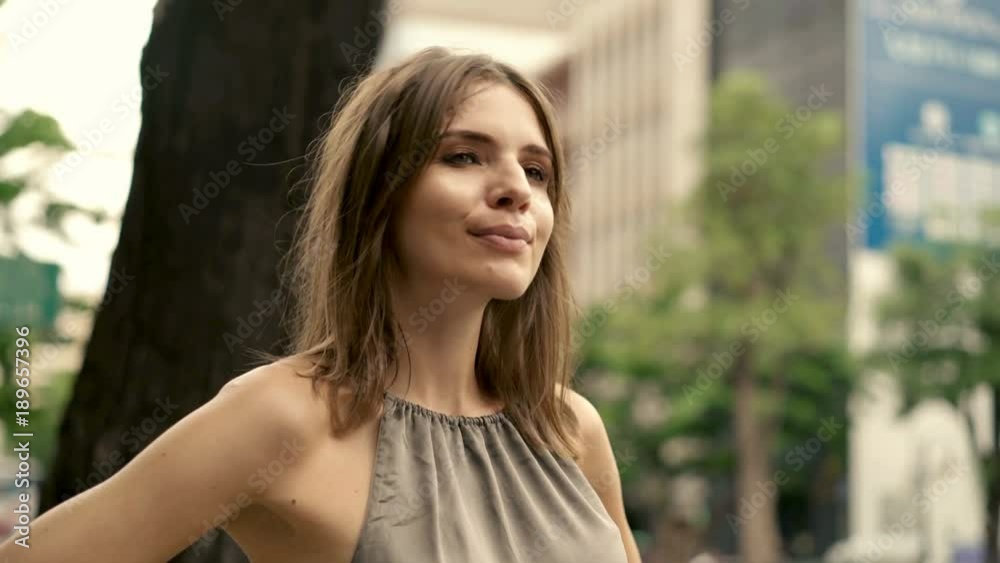 Happy, beautiful woman standing in the city 4K
