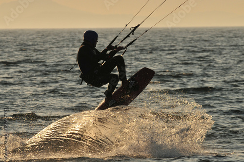 Kitesurfer creating a wave while jumping