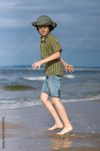 The guy is happy on the sandy beach of the sea.