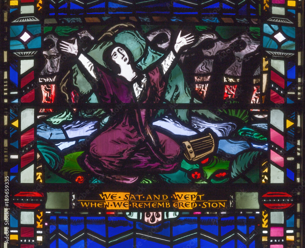 LONDON, GREAT BRITAIN - SEPTEMBER 16, 2017: The scene of The sorrow in the captivity of the Jews in Babylon on the stained glass in church St Etheldreda by Charles Blakeman (1953 - 1953).