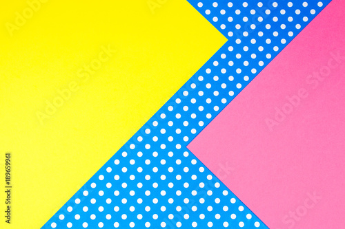 Abstract geometric yellow, pink and blue polka dot paper background.
