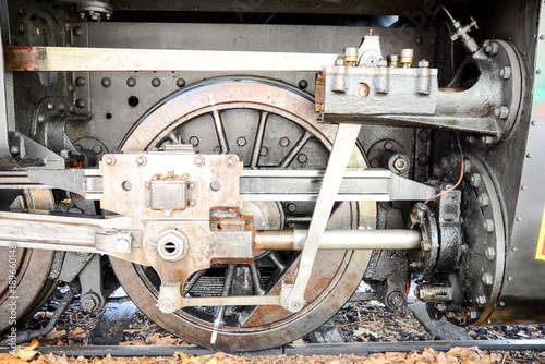 details of steel mechanism, wheels and piston of old steam train locomotive on a railway