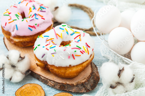 Donuts with icing on a white table, white eggs, Easter concept Menu, restaurant recipe concept Served in.