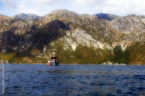 dark blue sea, boat with tourists, the mountains of Montenegro