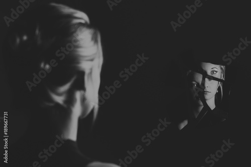 Woman looking at her face in shards of broken mirror artistic conversion