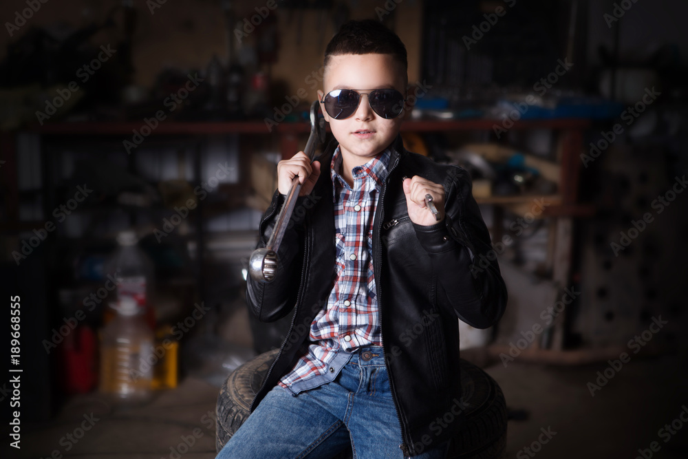 boy standing at the mechanic with tools in the garage boy standing at the mechanic with tools in the garage