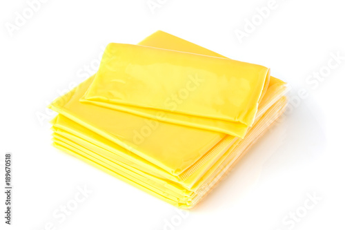Slices of processed cheese on a white background. Square slices of cheese for a burger close-up.