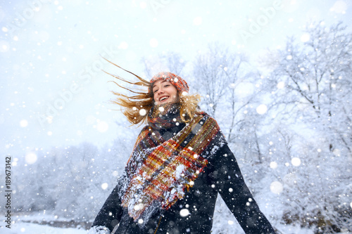 Young woman winter portrait. Expressing positivity, true brightful emotions. Beautiful model girl with shiny red long hair photo