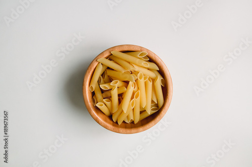Dried rigatoni pasta in wooden bowl