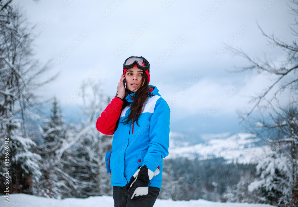 Woman talking on phone on background of winter landscape