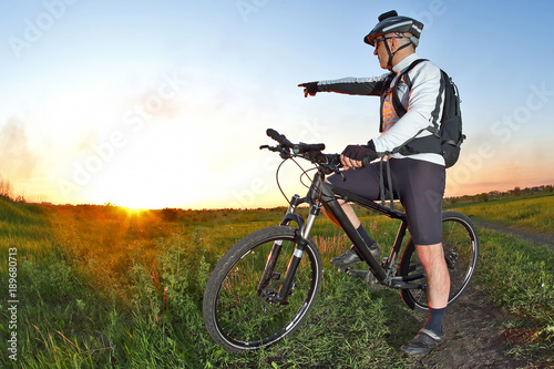 cyclist on Bicycle looks at sunset