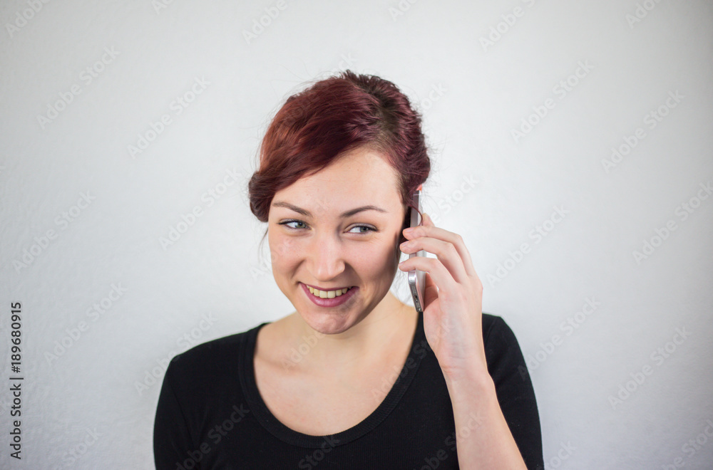 A young girl talking on a cell phone with a smile on her face, a white background, facial expressions A young girl talking on a cell phone with a smile on her face, a white background, facial expressions