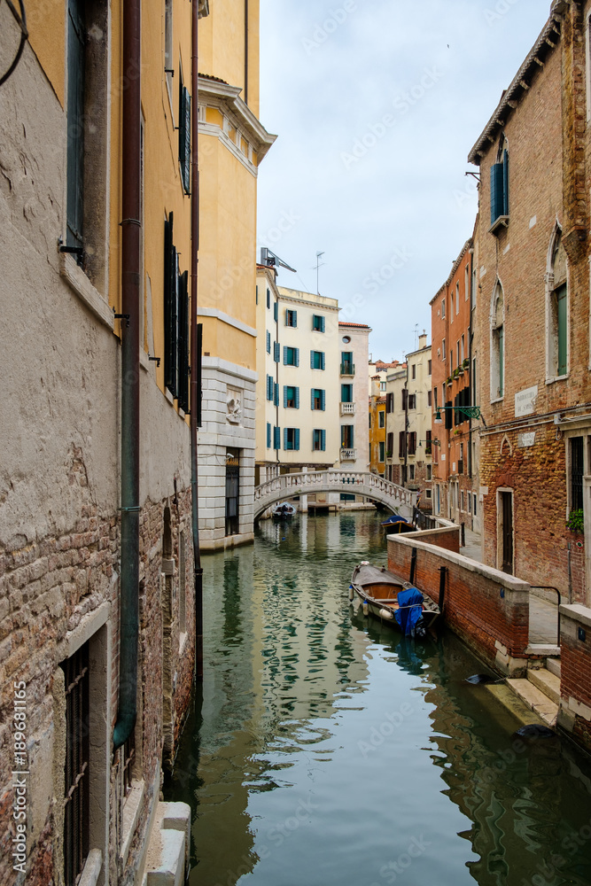 Narrow canal surrounded by old palaces in Venice