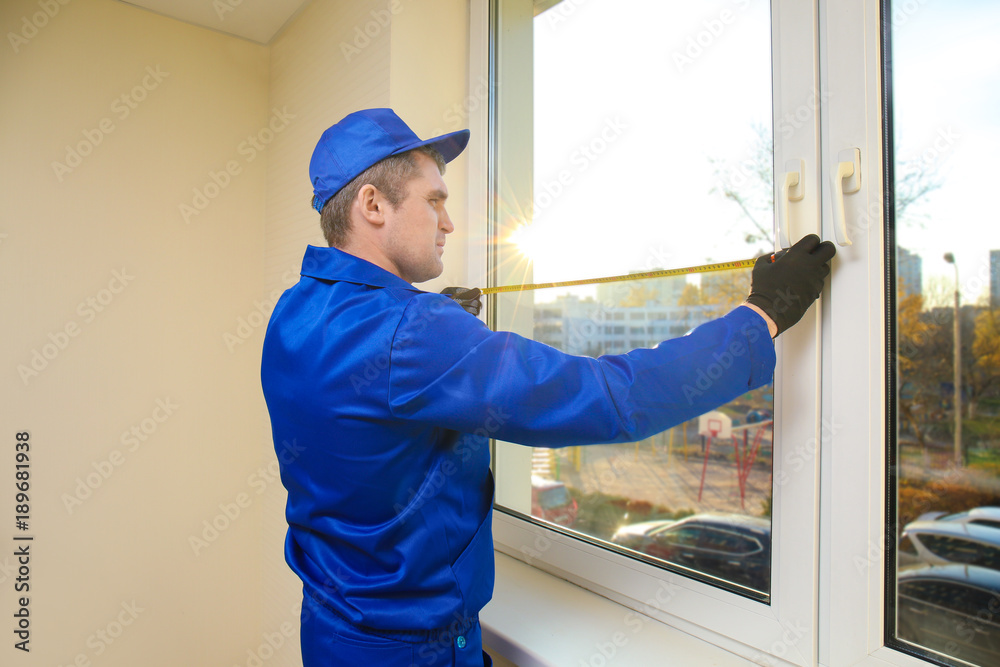 Construction worker repairing window in house Construction worker repairing window in house