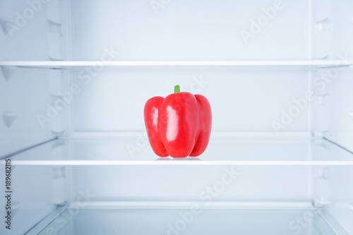 Fresh bell pepper in empty refrigerator