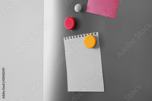 Blank sheets of paper and magnets on refrigerator door
