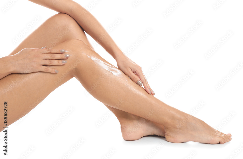 Woman applying body cream on her leg against white background, closeup Woman applying body cream on her leg against white background, closeup