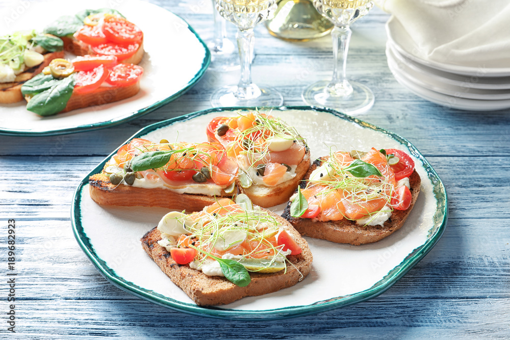 Tasty bruschettas with salmon, mozzarella and prosciutto on plate Tasty bruschettas with salmon, mozzarella and prosciutto on plate