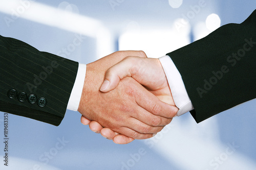 Zwei Männer geben sich erfolgreich die Hände nach Vertragsabschluss photo