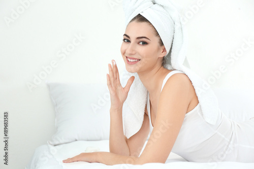 Young woman applying face c...