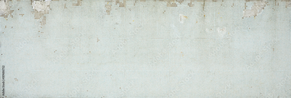 Naklejka premium The texture of the old wall, decorated with a lot of square small tiles. Wall in the style of architecture of the Soviet Union