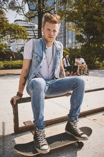 Young people use skatboard for relaxing time together outdoor at the city in the park