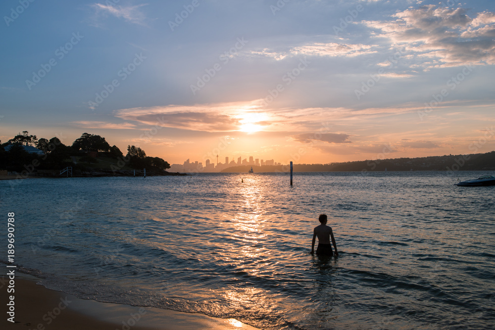 Silhouette of a man with Sydney skyline in the background.