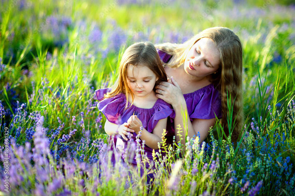 Happy healthy family concept. A young beautiful woman with her little cute daughter walking in the wheat gold field on a sunny summer day at sunset. Parents and kids relationship Happy healthy family concept. A young beautiful woman with her little cute daughter walking in the wheat gold field on a sunny summer day at sunset. Parents and kids relationship