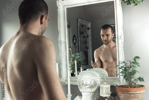 Great body image, confident young man checking himself out