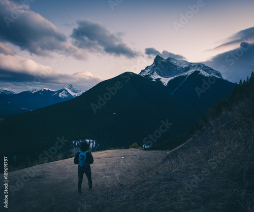 Female hiker looking out at the clouds near sunset