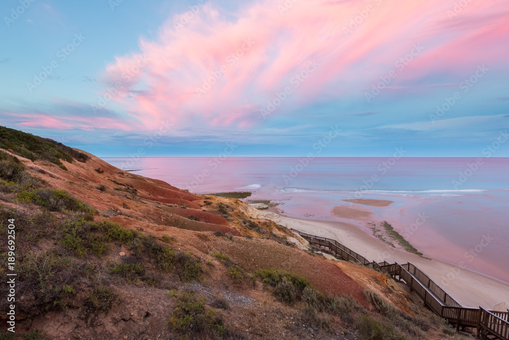 A very pink sunrise at southport port noarlunga overlooking the ocean and cliffs