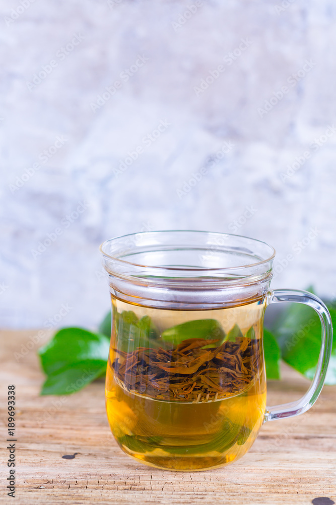 Loose leaf tea in a glass cup with a glass filter insert. Loose leaf tea in a glass cup with a glass filter insert.
