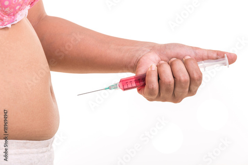 Fat woman holding syringe and inject red medicine to her belly isolated on white