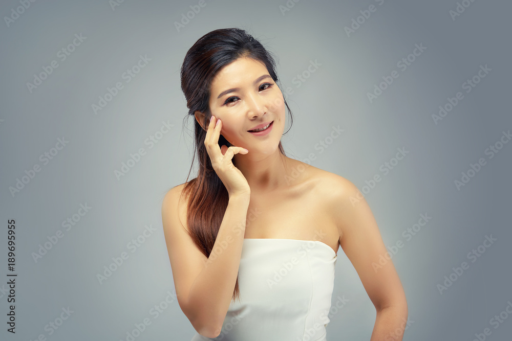 Happy beautiful asian girl with the fresh skin in grey colour background. Expressive facial expressions. Cosmetology and Spa concept. Happy beautiful asian girl with the fresh skin in grey colour background. Expressive facial expressions. Cosmetology and Spa concept.