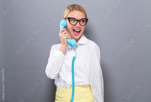 Young woman talking on old fashioned phone