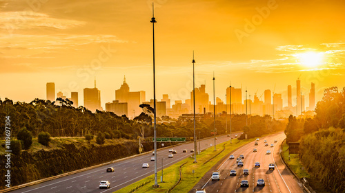 A view along the Eastern Freeway towards the cityscape of Melbourne, Australia during sunset.
