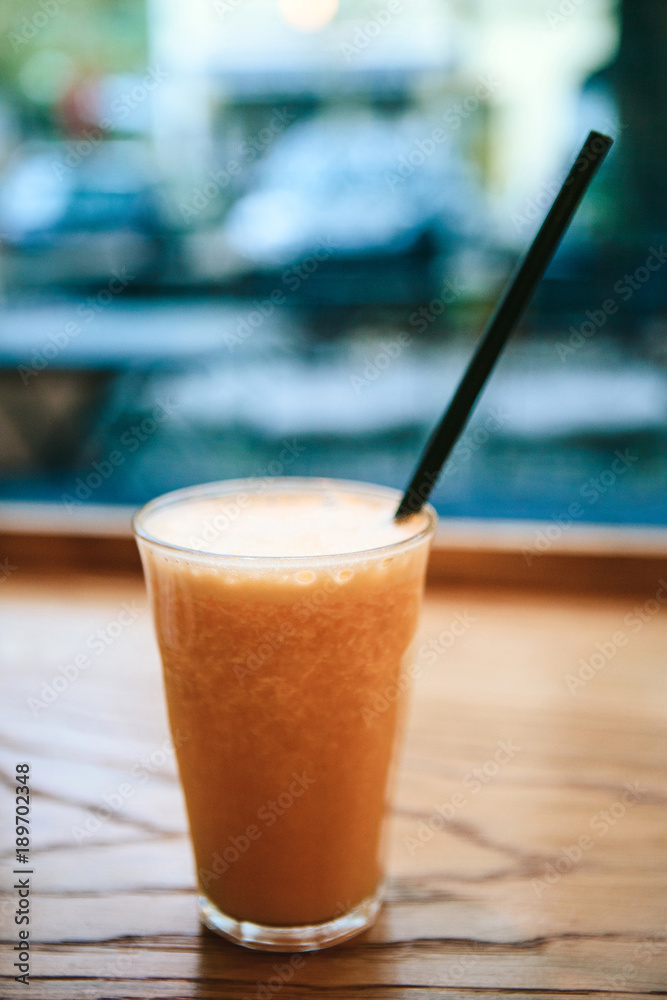 Fresh orange juice on a table in a cafe next to the window. Useful morning drink. Fresh orange juice on a table in a cafe next to the window. Useful morning drink.