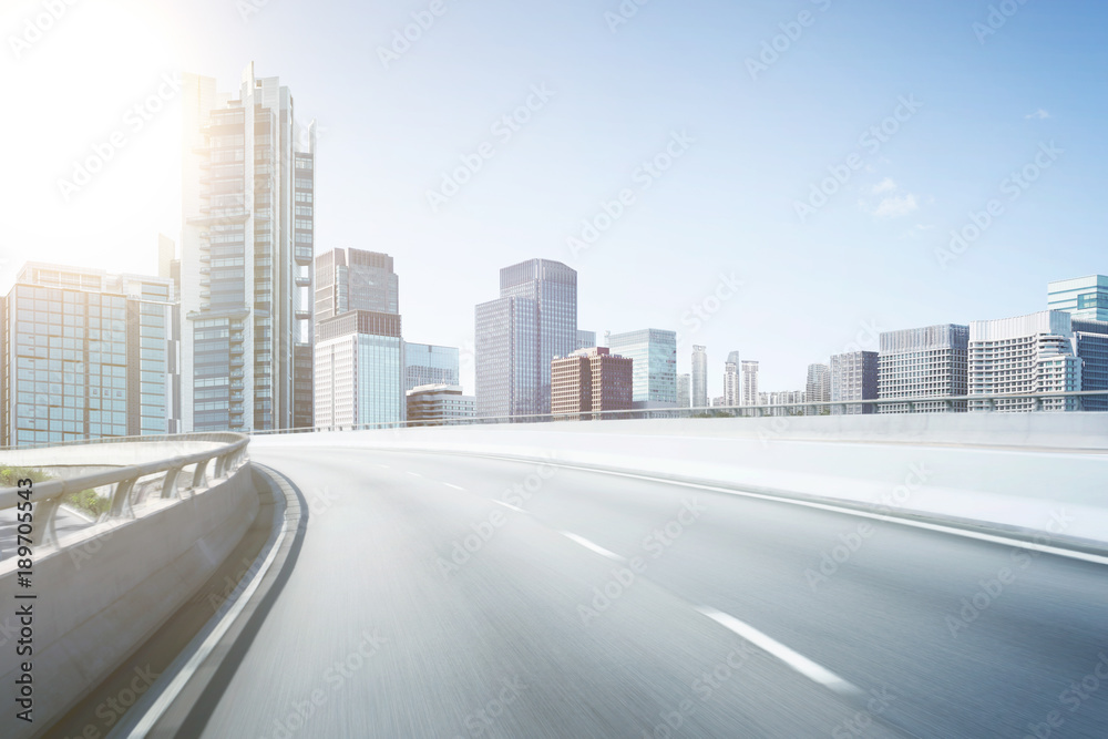 Motion blur flyover asphalt road with modern skyscraper building background.