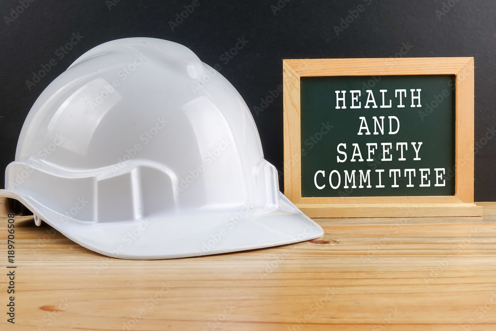 HEALTH AND SAFETY CONCEPT. Personal protective equipment on wooden table over black background with HEALTH AND SAFETY COMMITTEE TEXT - obrazy, fototapety, plakaty 
