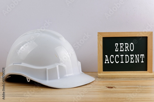 ZERO ACCIDENT CONCEPT. Personal protective equipment on wooden table over white background.