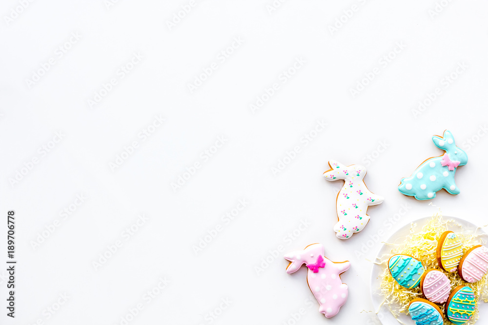 Easter background. Cookies in shape of easter bunny and easter eggs. White background top view space for text