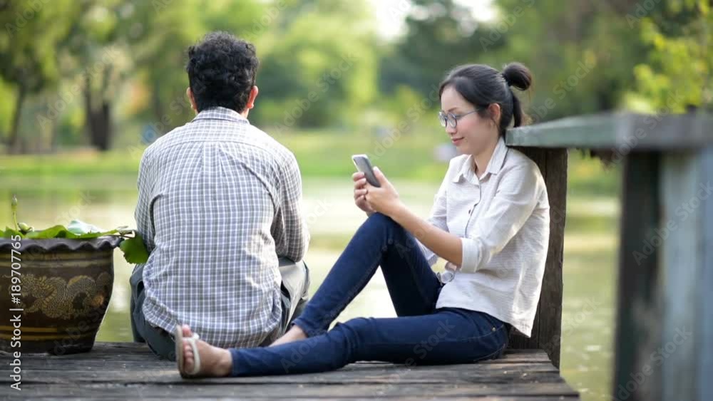 Asian woman sitting beside the lake in the park. Asian woman sitting beside the lake in the park.