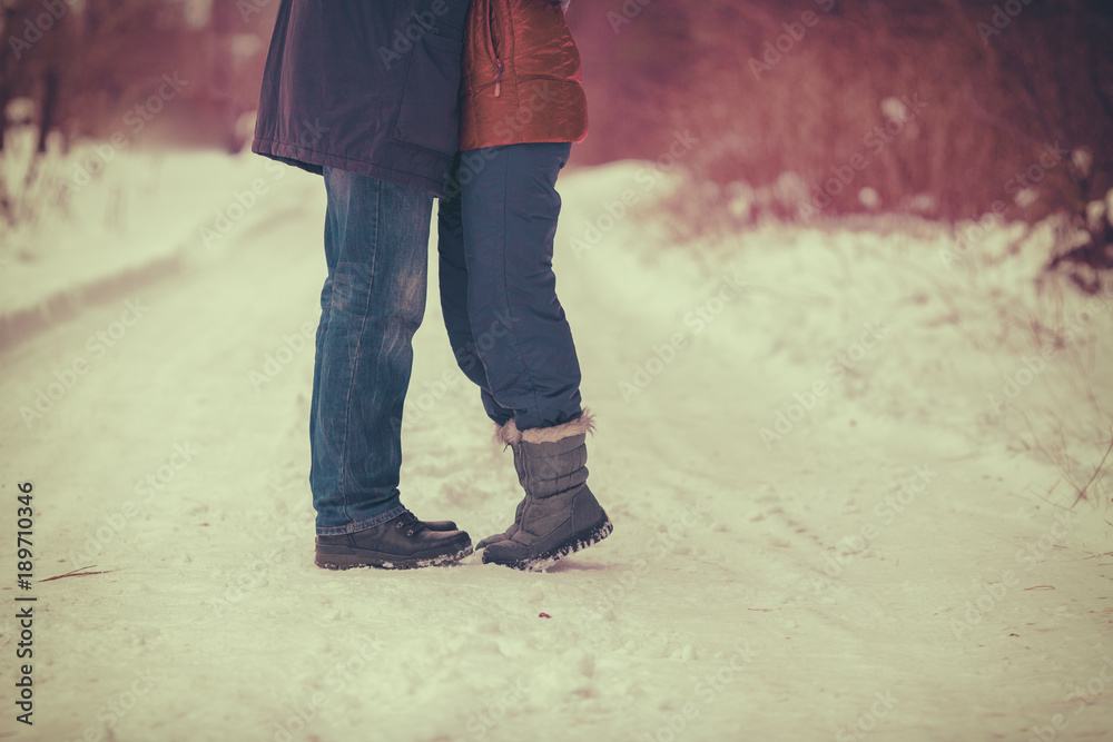 The couple in love outdoors in winter. Man and woman kissing and hugging