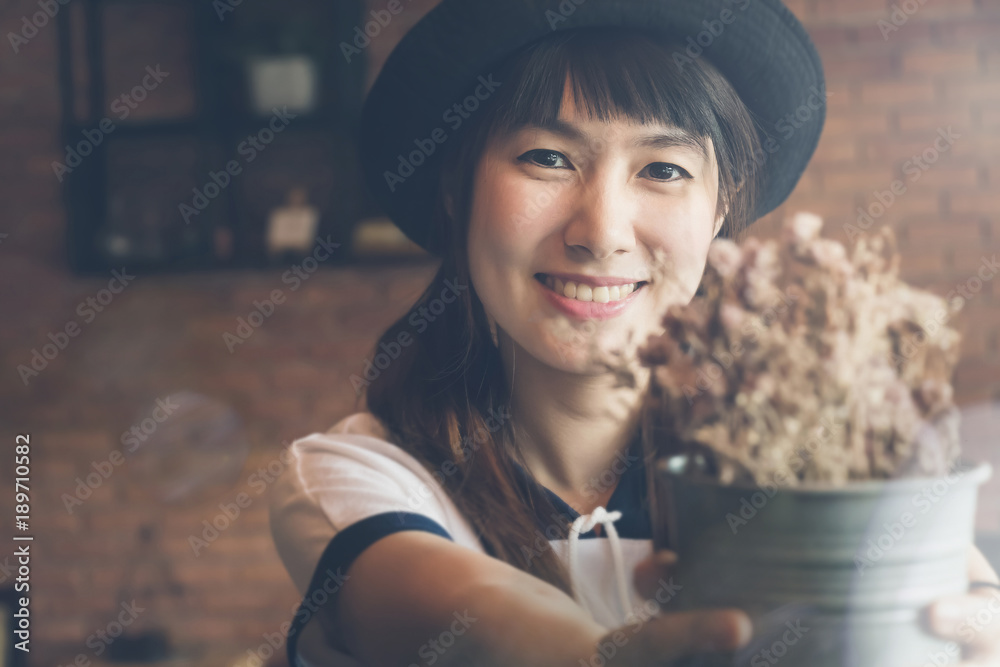 Young beautiful asia woman smiling happiness with flowerpot on gray background in coffee shop. Young beautiful asia woman smiling happiness with flowerpot on gray background in coffee shop.