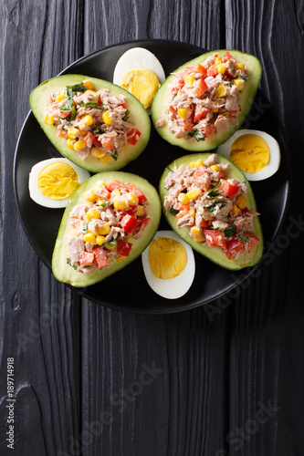 Delicious snack of avocado stuffed with tuna salad closeup. Vertical top view