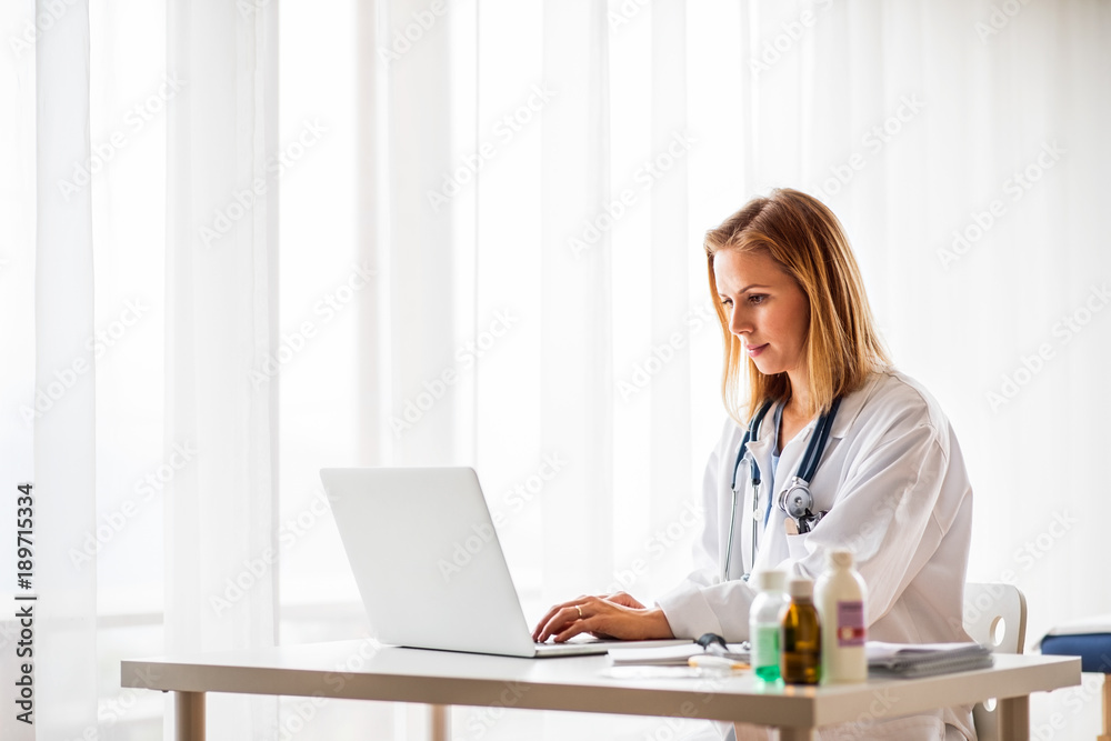 Female doctor with laptop working at the office desk. Female doctor with laptop working at the office desk.