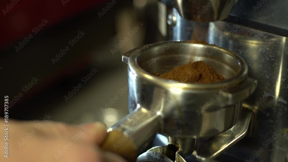 Barista grinding freshly roasted coffee Barista grinding freshly roasted coffee